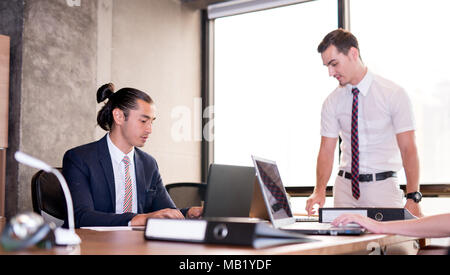 Image of two young businessmen discussing project at meeting.Business presentation. focus on Man sitting Stock Photo