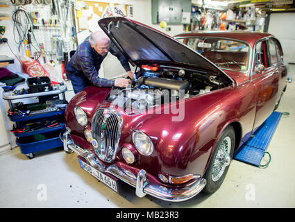 Wolfsburg, Germany. 27th Mar, 2018. 27 March 2018, Germany, Wolfsburg: Vintage car collector Horst F. Beilharz inspects his Jaguar S-Type. Credit: Hauke-Christian Dittrich/dpa/Alamy Live News Stock Photo