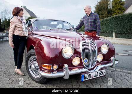 27 March 2018, Germany, Wolfsburg: Vintage car collector Horst F. Beilharz and his wife Hermine stand next to their Jaguar S-Type. The couple travelled across Great Britain with old cars. Photo: Hauke-Christian Dittrich/dpa Stock Photo