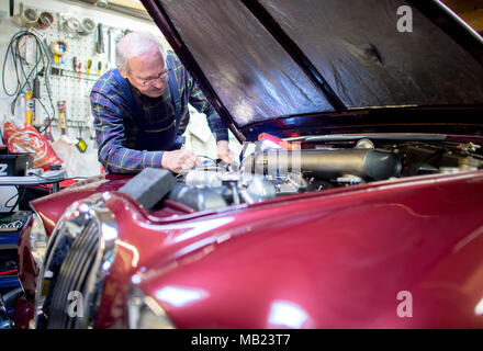 Wolfsburg, Germany. 27th Mar, 2018. 27 March 2018, Germany, Wolfsburg: Vintage car collector Horst F. Beilharz inspects his Jaguar S-Type. Credit: Hauke-Christian Dittrich/dpa/Alamy Live News Stock Photo
