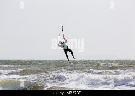 Sandbanks, Poole, Dorset, UK. 6th April, 2018. UK weather: breezy day at Sandbanks as kite surfer makes the most of the windy conditions to get high in the air, airborne. kitesurfers kite surfers kite surfer kiteboarders kite boarders kitesurfer kitesurfing kite surfing kiteboarding kite boarding kiteboarder kite boarder  Credit: Carolyn Jenkins/Alamy Live News Stock Photo