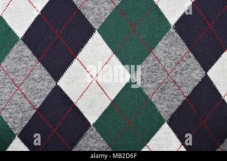 Pattern of a warm female sweater from black, white and green  rhombuses and red  lines. Mass production background Stock Photo