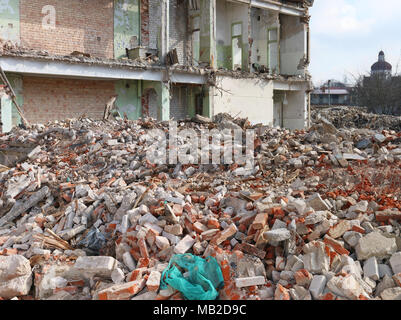 A huge pile of bricks. concrete stones  and construction debris remained after the destruction of the dilapidated apartment house. Panoramic shot from Stock Photo