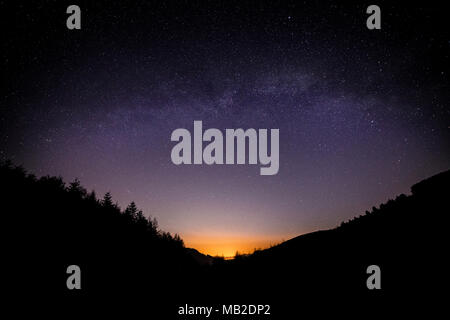 Milky Way arching over the Clwydian Forest at Moel Famau, North Wales Stock Photo