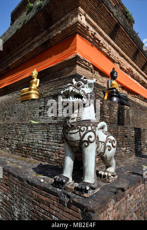 Singha lion and Buddha statues at pagoda Chedi of temple Wat Lok Mori, Chiang Mai, Thailand Stock Photo