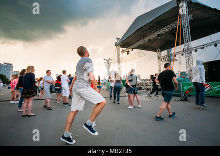 MINSK, BELARUS - MAY 9, 2014: Young people dancing during rain in front of the Palace of Sports. Stock Photo