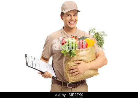 Delivery guy holding a clipboard and a grocery bag isolated on white background Stock Photo