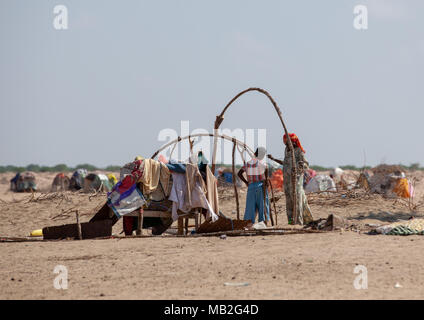 Family building a somali hut called aqal in the desert, Awdal region, Lughaya, Somaliland Stock Photo