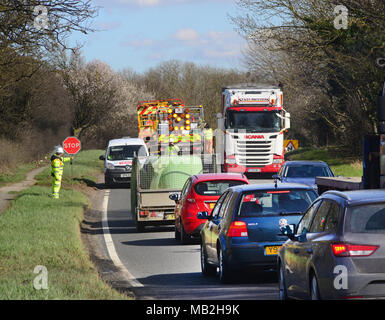 construction worker using lollipop stop - go sign to control traffic at roadworks united kingdom Stock Photo