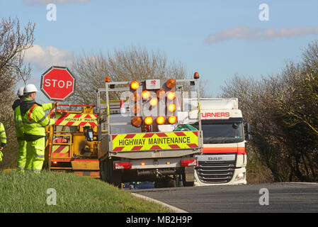 construction worker using lollipop stop - go sign to control traffic at roadworks united kingdom Stock Photo