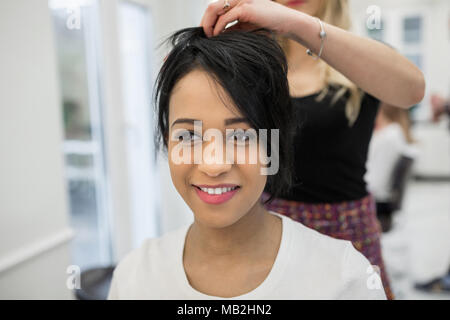 Portrait of young woman having hair styling in salon Stock Photo