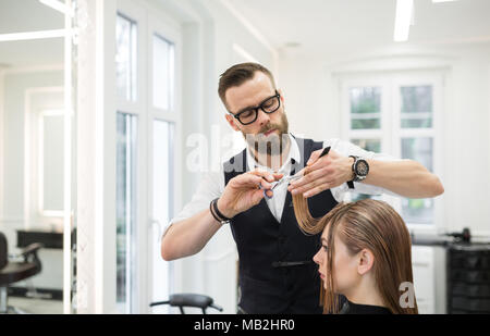 Male stylist cutting the hair of female client in professional beauty salon  Stock Photo - Alamy
