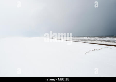Snow covered beach looking west towards Blakeney Point from Cley North Norfolk February Stock Photo