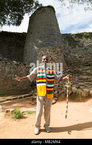 Lovemore, a guide at Great Zimbabwe near Masvingo in Zimbabwe. He explains about the stonework buildings that were the capital of the Kingdom of Zimba Stock Photo