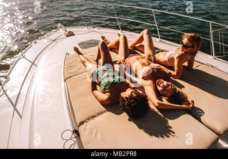 https://l450v.alamy.com/450v/mb2pr8/smiling-young-women-wearing-swimsuits-lying-on-the-deck-of-a-small-boat-in-the-sea-girls-sunbathing-on-luxury-yacht-mb2pr8.jpg