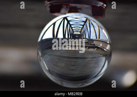 A railroad track and bridge seen through a crystal ball. A visual metaphor for vision, moving forward while staying on track and crossing bridges. Stock Photo