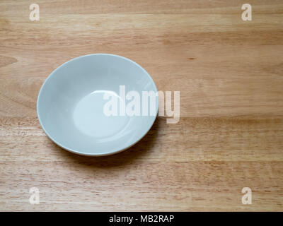 Angled shot of porcelain bowl with on chopping block. Subtle shadow going down Stock Photo