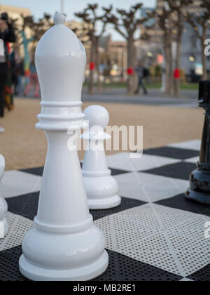 Giant, life-sized bishop piece on a chess board in a park Stock Photo