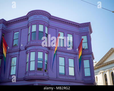 Purple house with LGBT pride rainbow flags hanging on a sunny day Stock Photo