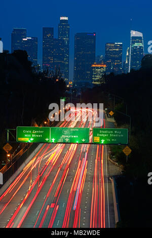 Light trails on the Arroyo Seco Parkway with Downtown Los Angeles in the distance. Los Angeles County, California, USA. Stock Photo