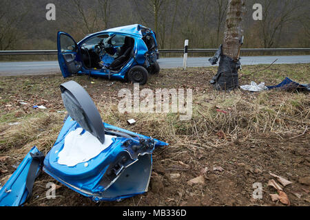 Car accident on country road, car with rear peprallt against a tree, Germany