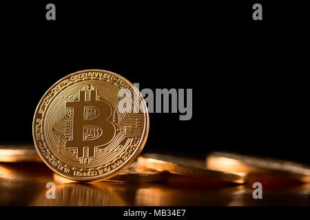 One golden bitcoin on its edge shown on the background of other cryptocurrencies introducing future trend of virtual money. Blockchain web digital currency innovation mining stock exchange finance Stock Photo