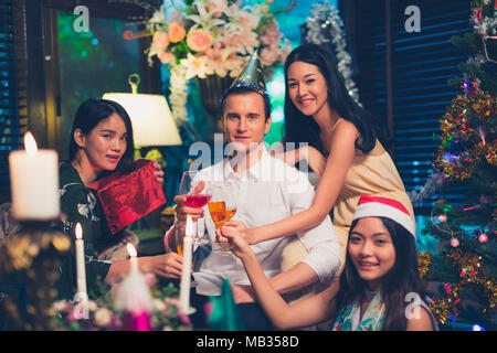 Group Of Friends Enjoying Christmas Drinks In Bar Celebrating x mas at home Stock Photo