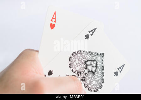 Heart and spades aces of cards in the hand on white background Stock Photo
