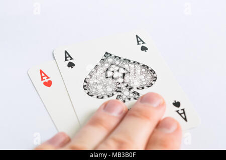 Heart and spades aces of cards in the hand on white background Stock Photo