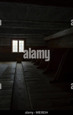 Old stable for livestock, with light coming in from a single window. Stock Photo