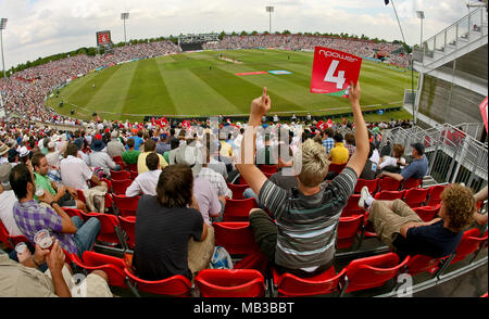 A fan at the finals day of the twenty20 2008 cricket trophy at the Rose Bowl in Hampshire Southampton cheers and hold up a 4 card in the crowd with a view of the field of play. Stock Photo