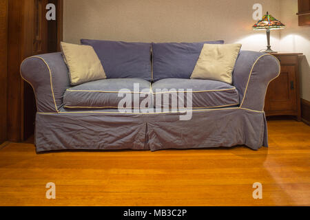BLUE COUCH ON OAK WOODEN LIVING ROOM FLOOR Stock Photo