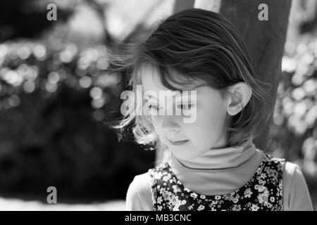 Black and white image of young girl looking pensive Stock Photo