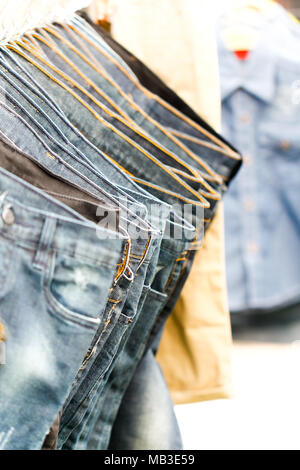 Row of hanged blue jeans in a shop. Stock Photo