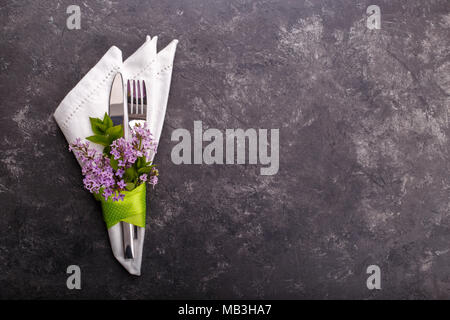Spring festive table setting with cutlery and lilac flowers on black stone table,copy space flat lay Stock Photo