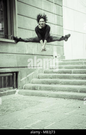 Male dancer performing jump in the air. Urban background Stock Photo