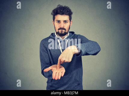 Young serious hipster man asking for more money to pay back debt Stock Photo