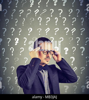 Stressed overburdened young man has too many questions and no answer Stock Photo