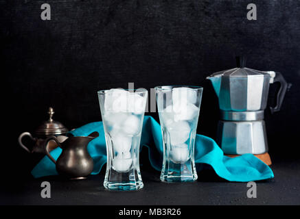 two empty glasses of ice on the table. and a coffee maker in the background. pure composition Stock Photo