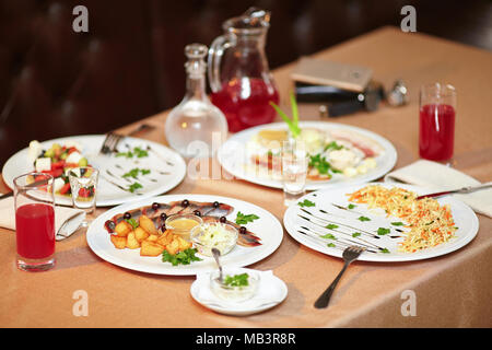 Table with salad and snacks in restaurant served for two persons Stock Photo