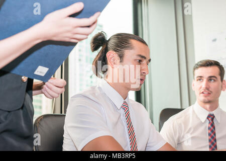 Young employee businessman looking at computer monitor during working day in office Stock Photo