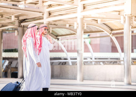 Arabic Middle eastern businessman doing business trip and walk at airport while carrying luggage Stock Photo