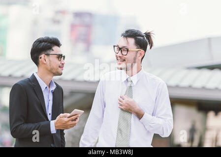 Having a break to talk around. Two cheerful business men talking and gesturing while standing outdoors Stock Photo