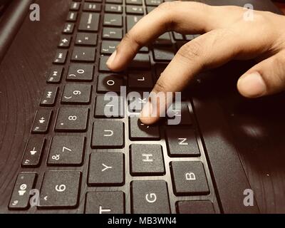 Typing on laptop keyboard keys. Stock Photo