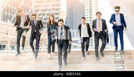 Portrait of hurrying people in suits run forwards for work with optimistic expression.Business people running in city .Team work rush hour and competi Stock Photo