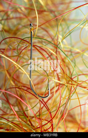 very tangled fishing line, hook in the foreground, all on white