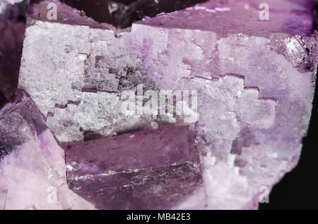Fluorite surface closeup. Cubic crystals of fluorspar, a mineral form of calcium fluoride, CaF2. Colorful pink and purple crystal cluster. Stock Photo