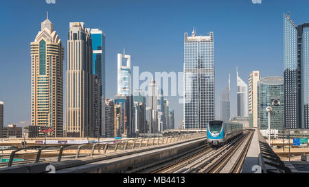 A Dubai Metro train  and downtown office towers in Dujbai, UAE, Middle East. Stock Photo