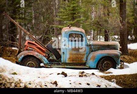 An old, blue 1946 Ford tow truck, on the side of a barn, in Noxon, Montana. Stock Photo