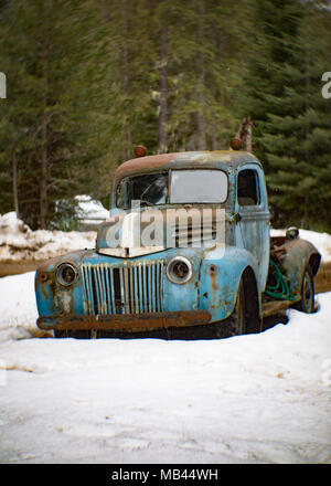 An old, blue 1946 Ford tow truck, on the side of a barn, in Noxon, Montana. Stock Photo